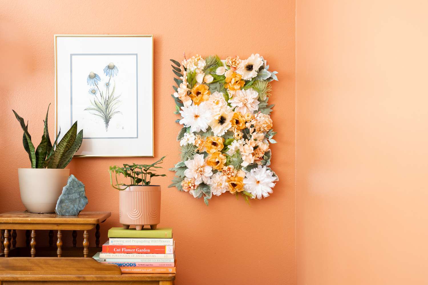 Tablero de pared de flores DIY colocado en una pared naranja