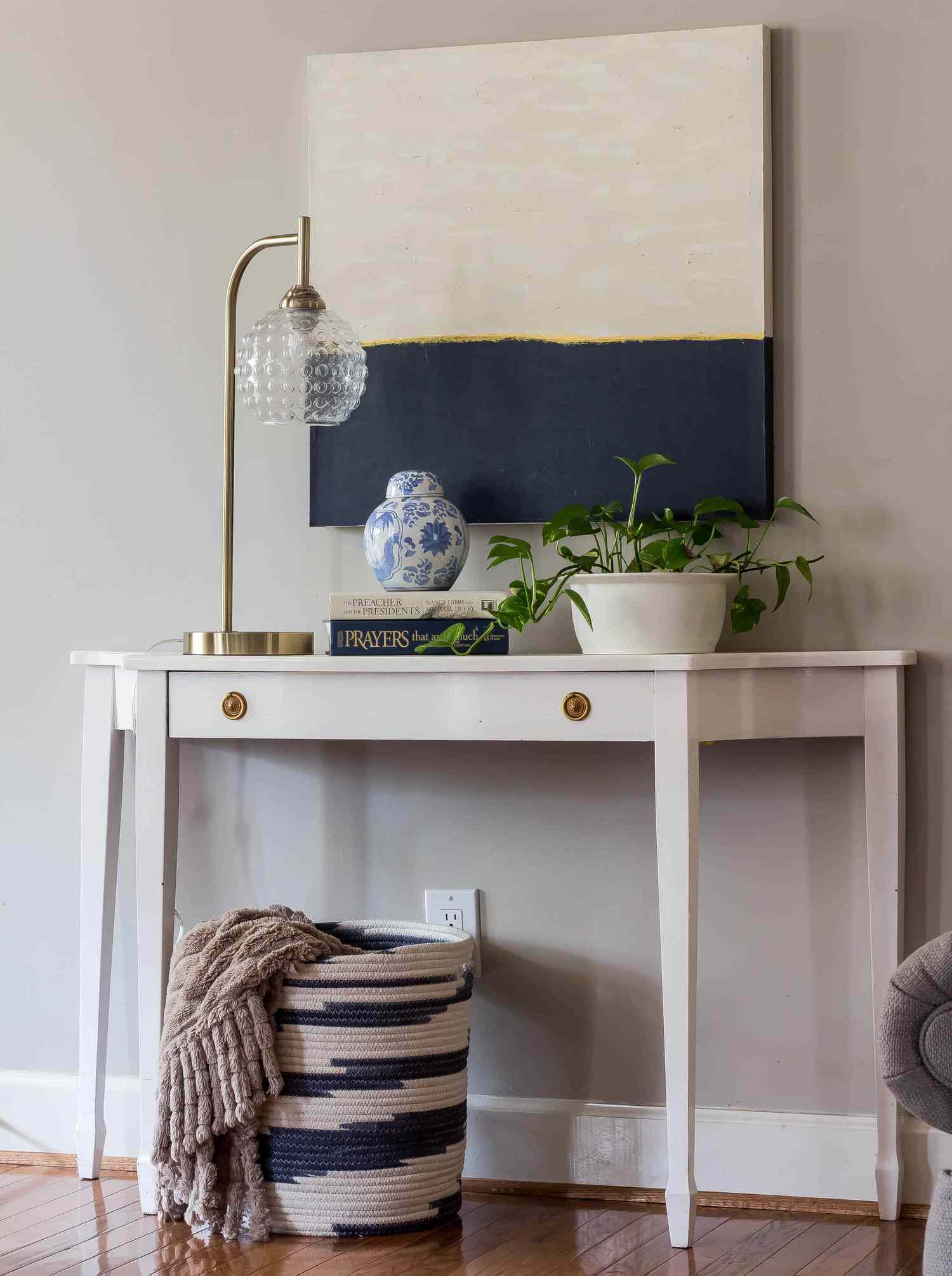 A tan and navy canvas above a white desk