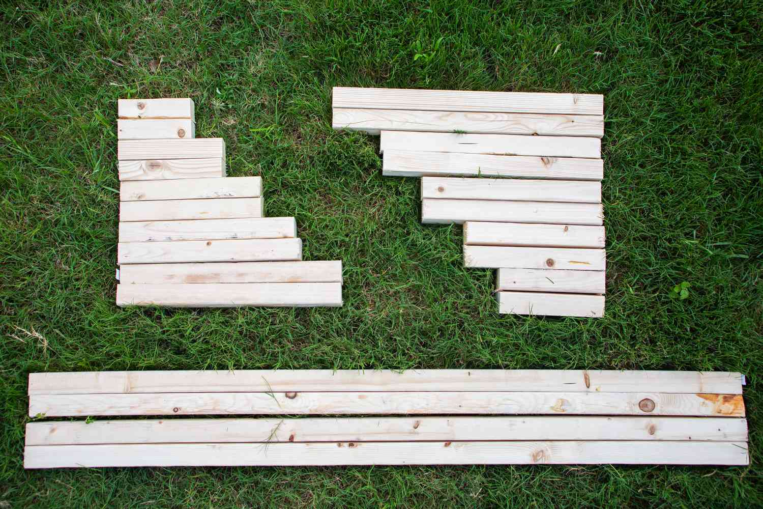 Pedaços de madeira cortados em vários tamanhos e colocados na grama