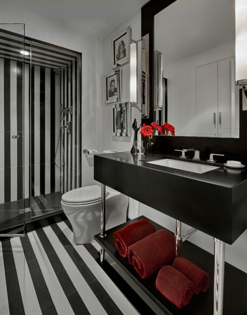 Banheiro listrado em preto e branco com detalhes em vermelho