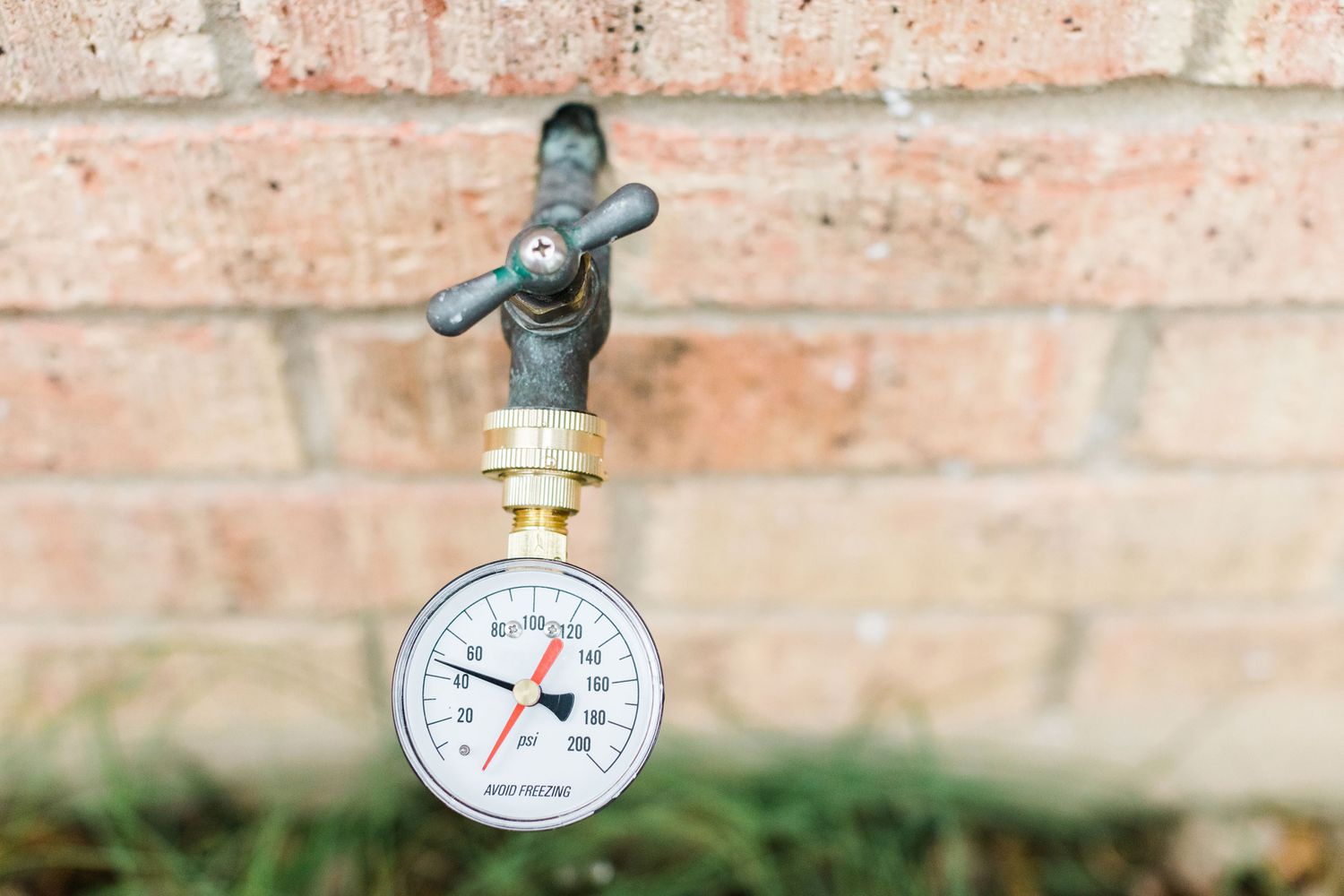 Water pressure gauge measuring pressure on outdoor faucet 