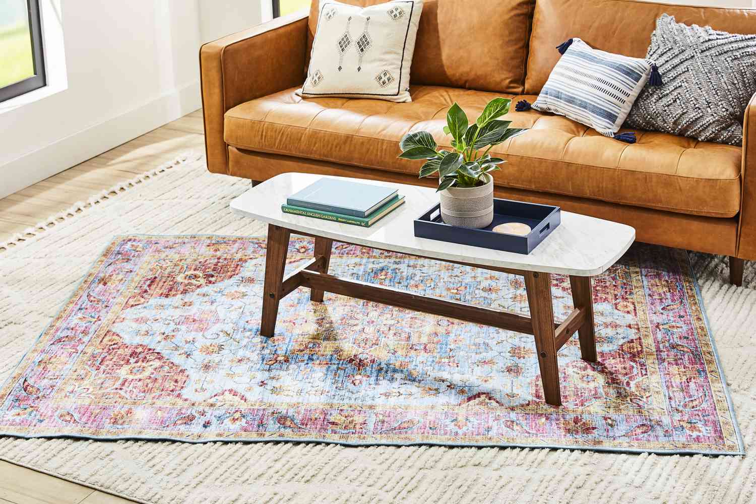 Una colorida alfombra estampada superpuesta sobre una alfombra neutra