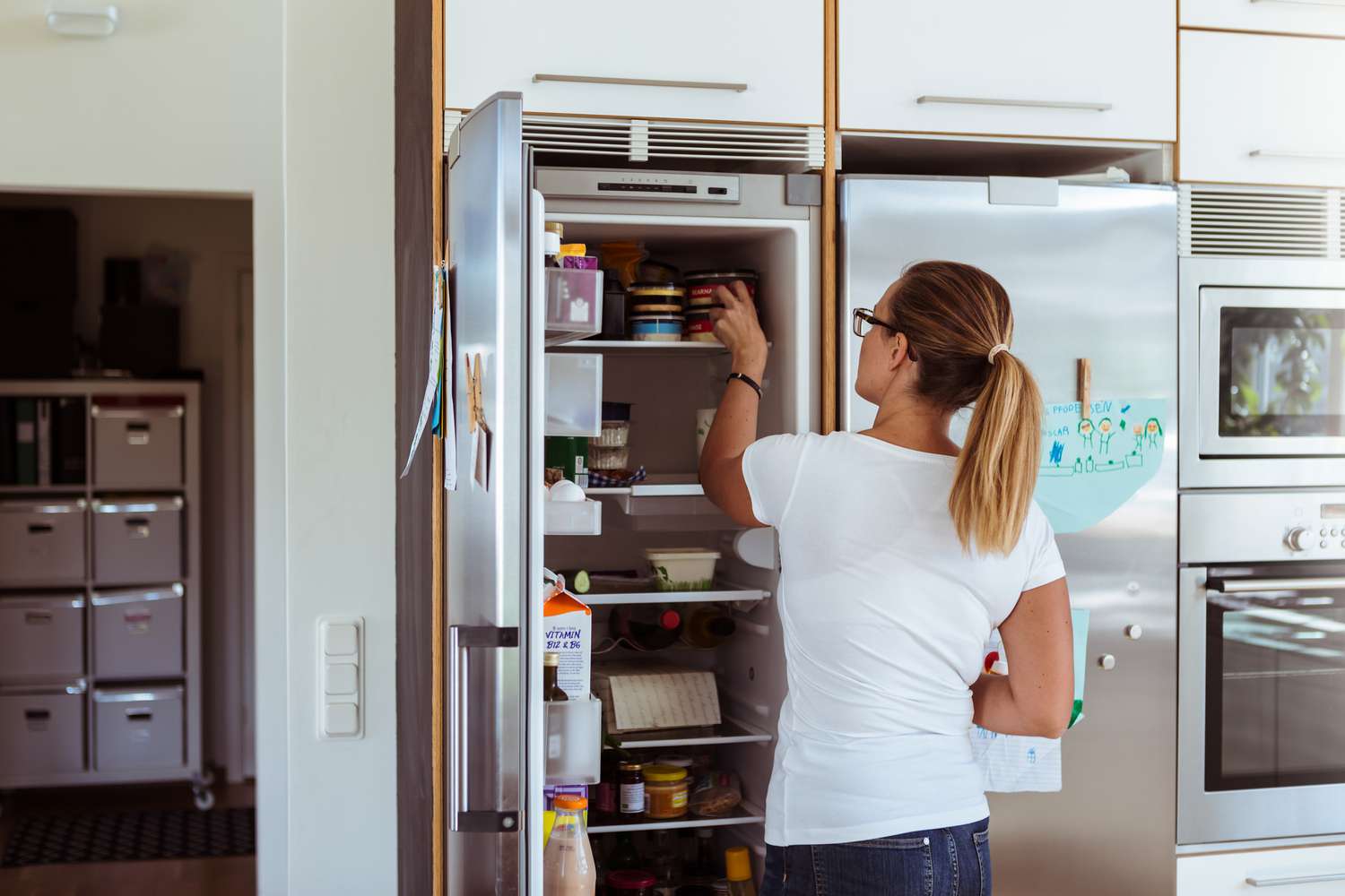 Eine Frau ordnet ihren Kühlschrank.