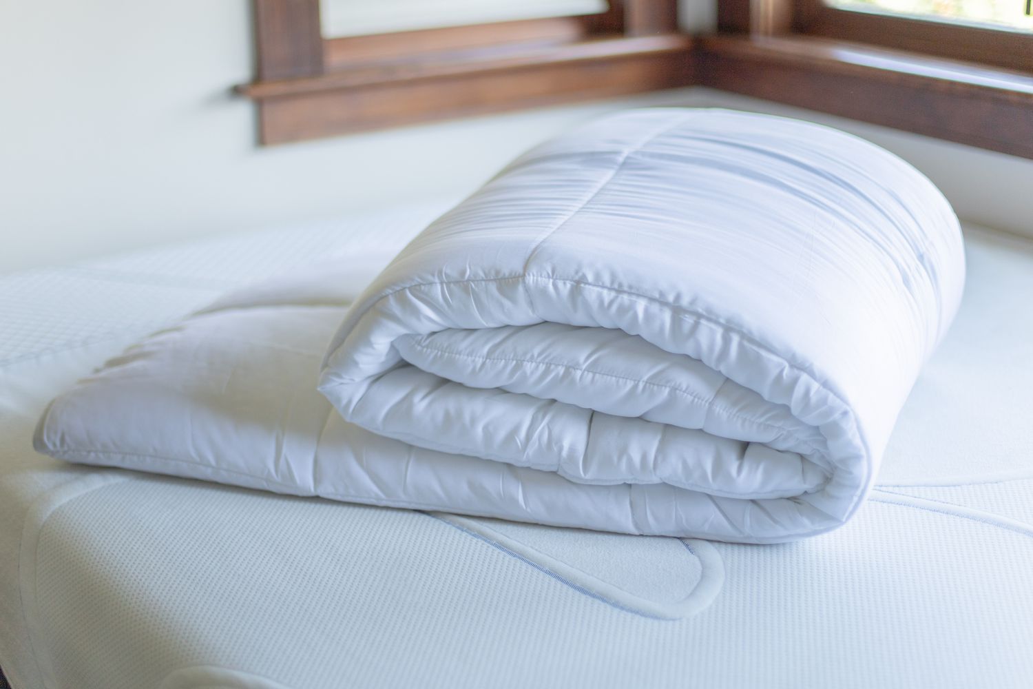 comforter folded on top of a mattress