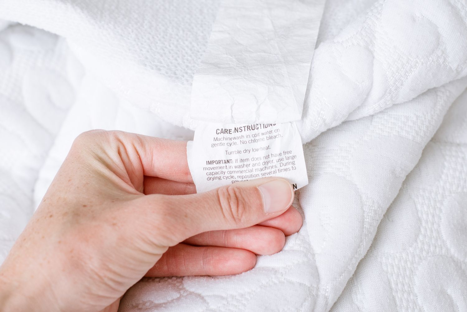 Matratzenschoner-Etikett wird vor der Reinigung überprüft