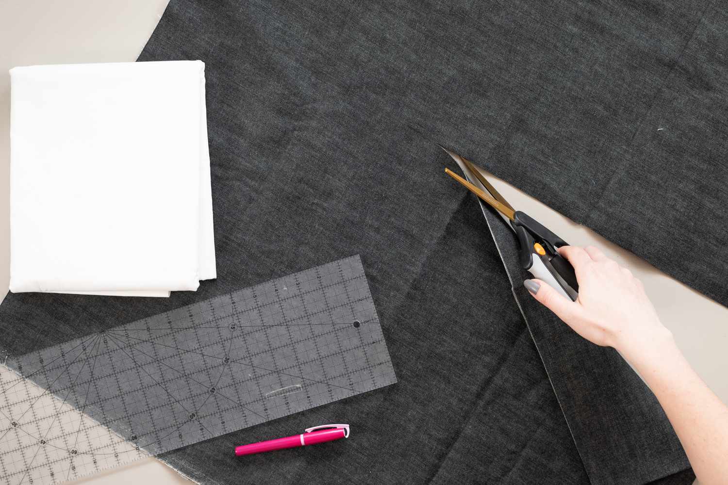 Black home decor fabric being cut for DIY Roman shades