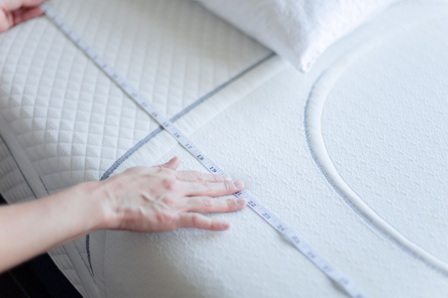 person taking a mattress measurement