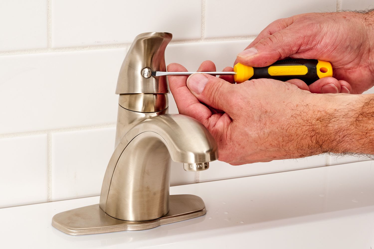 Lever handle removed from faucet with Allen-head screwdriver
