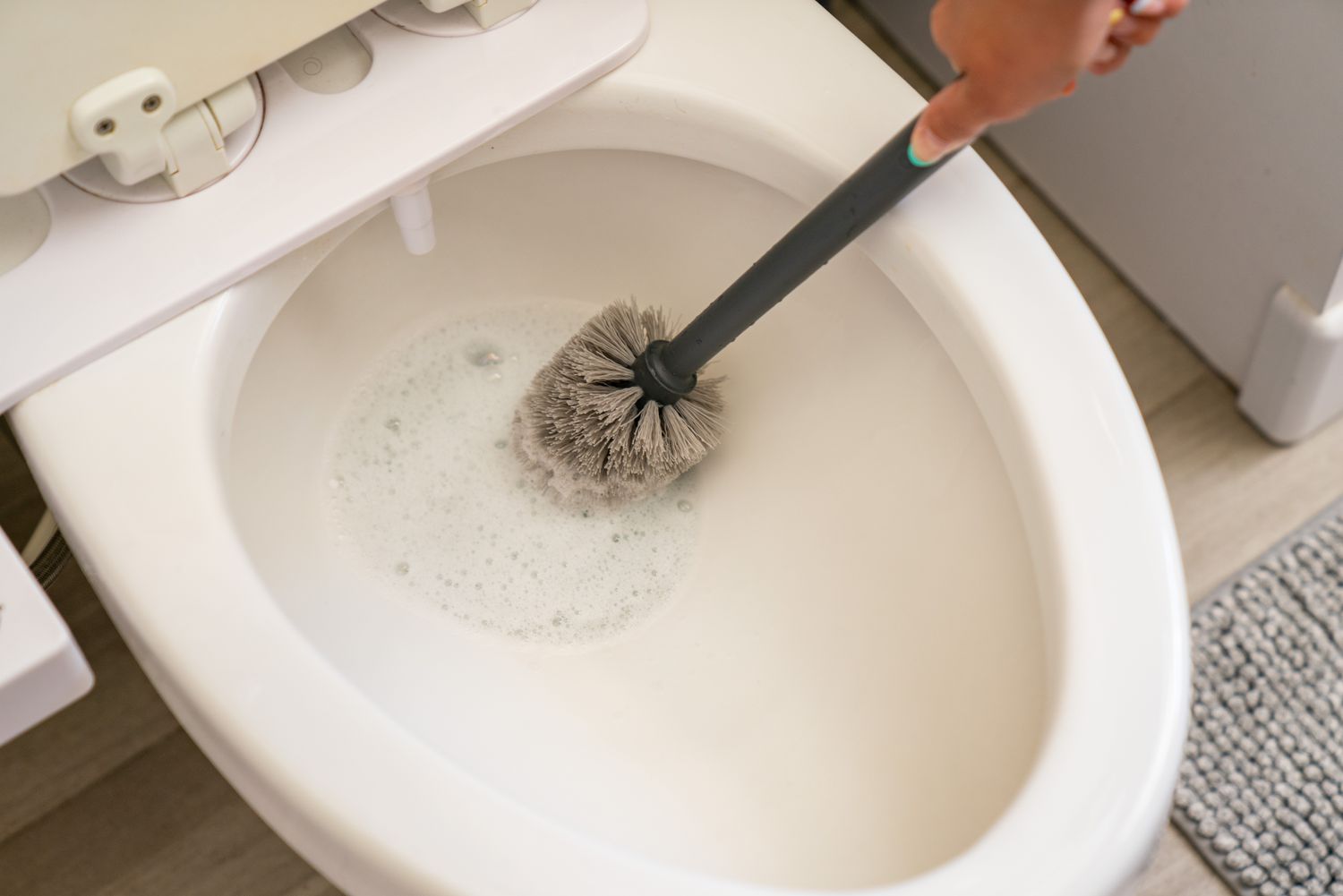 Cuvette de salle de bain nettoyée avec un nettoyant multi-usages et une brosse à récurer