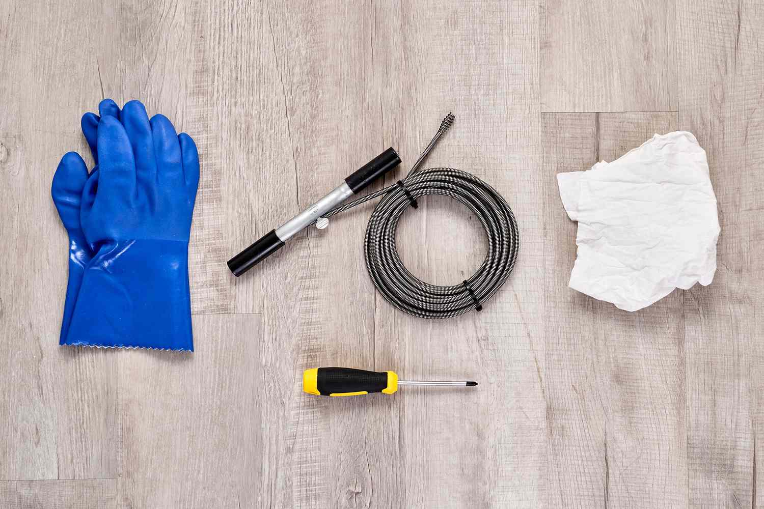 Materialien und Werkzeuge zum Reinigen eines Duschabflusses mit einer Abflussschlange