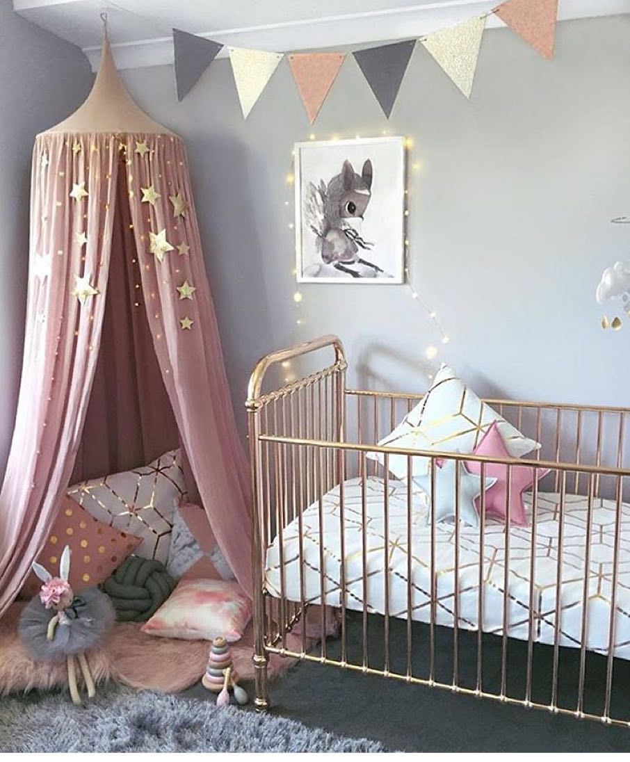 Cozy canopy tent reading corner in pink and grey nursery room