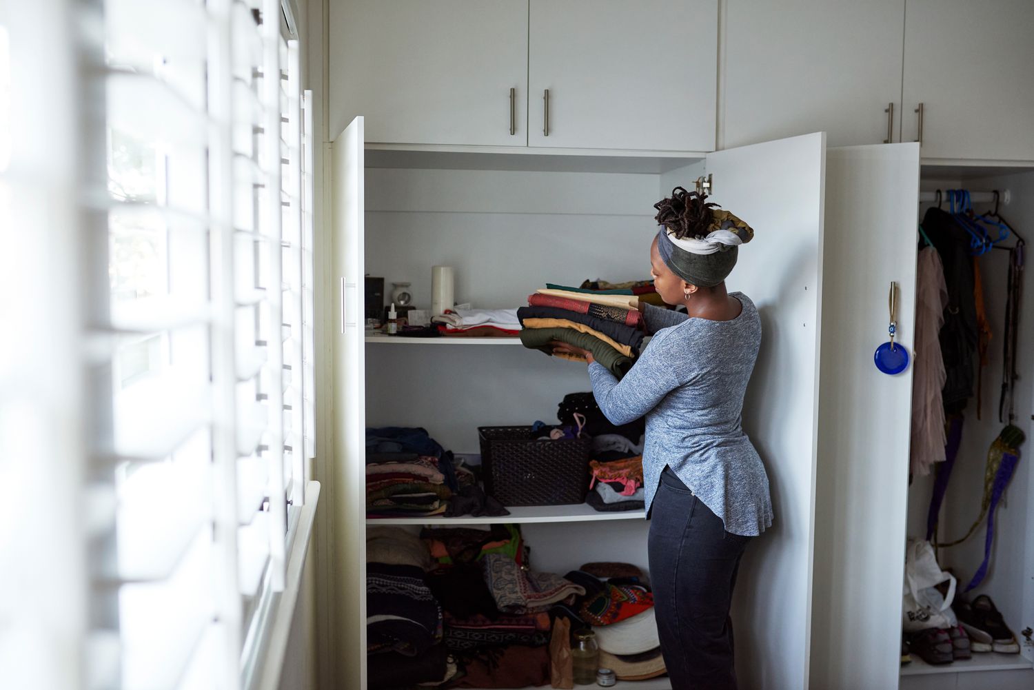 Eine Frau legt gefaltete Kleidung in einen Schrank