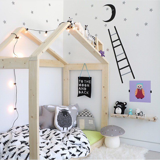 Kinderzimmer im nordischen Stil mit skurrilem Bett mit Hausrahmen.