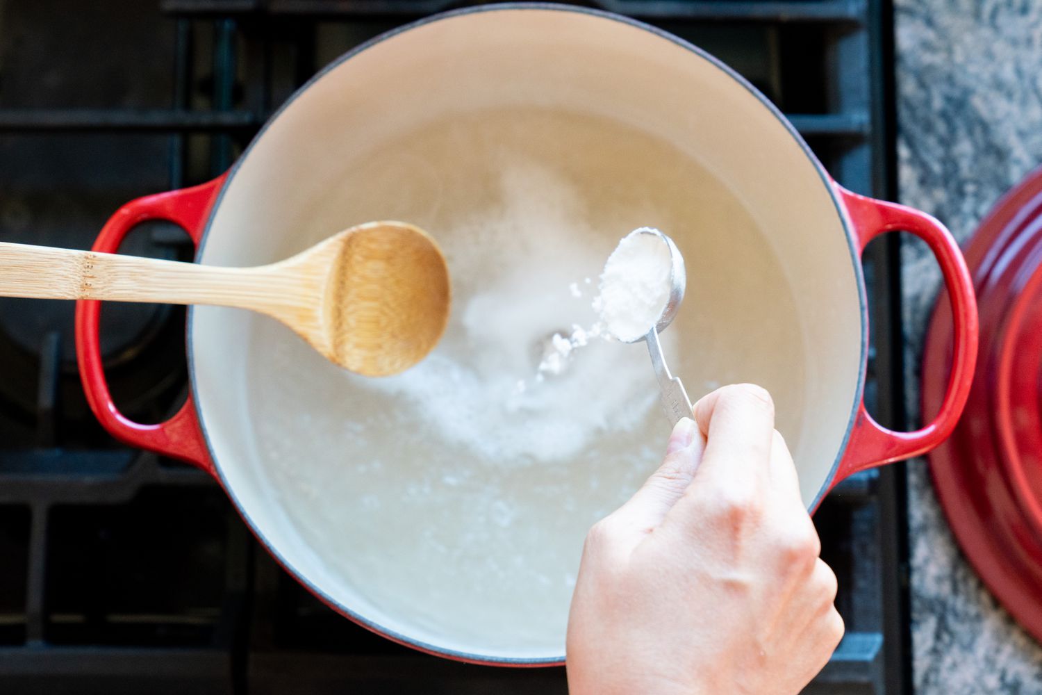 Backpulver in einen Emaille-Topf mit kochendem Wasser gegossen und umgerührt