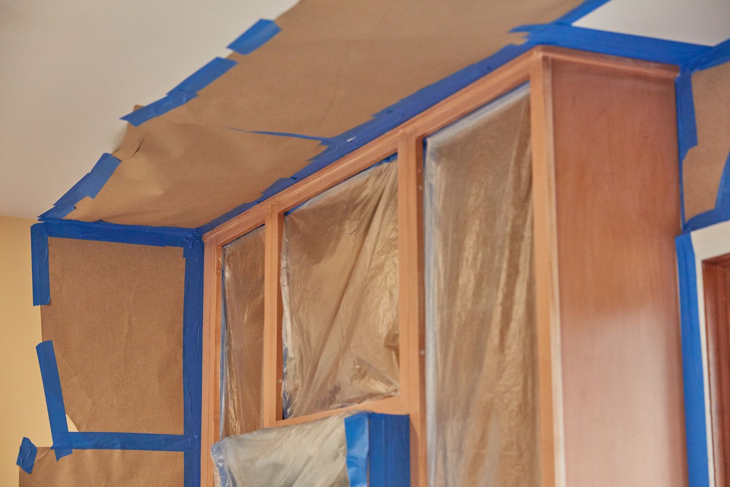 Paredes y techo de la cocina enmascarados con cinta de pintor para prohibir que se pinte sobre ellos