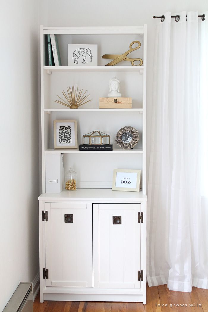 Ein weißer Schrank und ein Bücherregal in einem Wohnzimmer