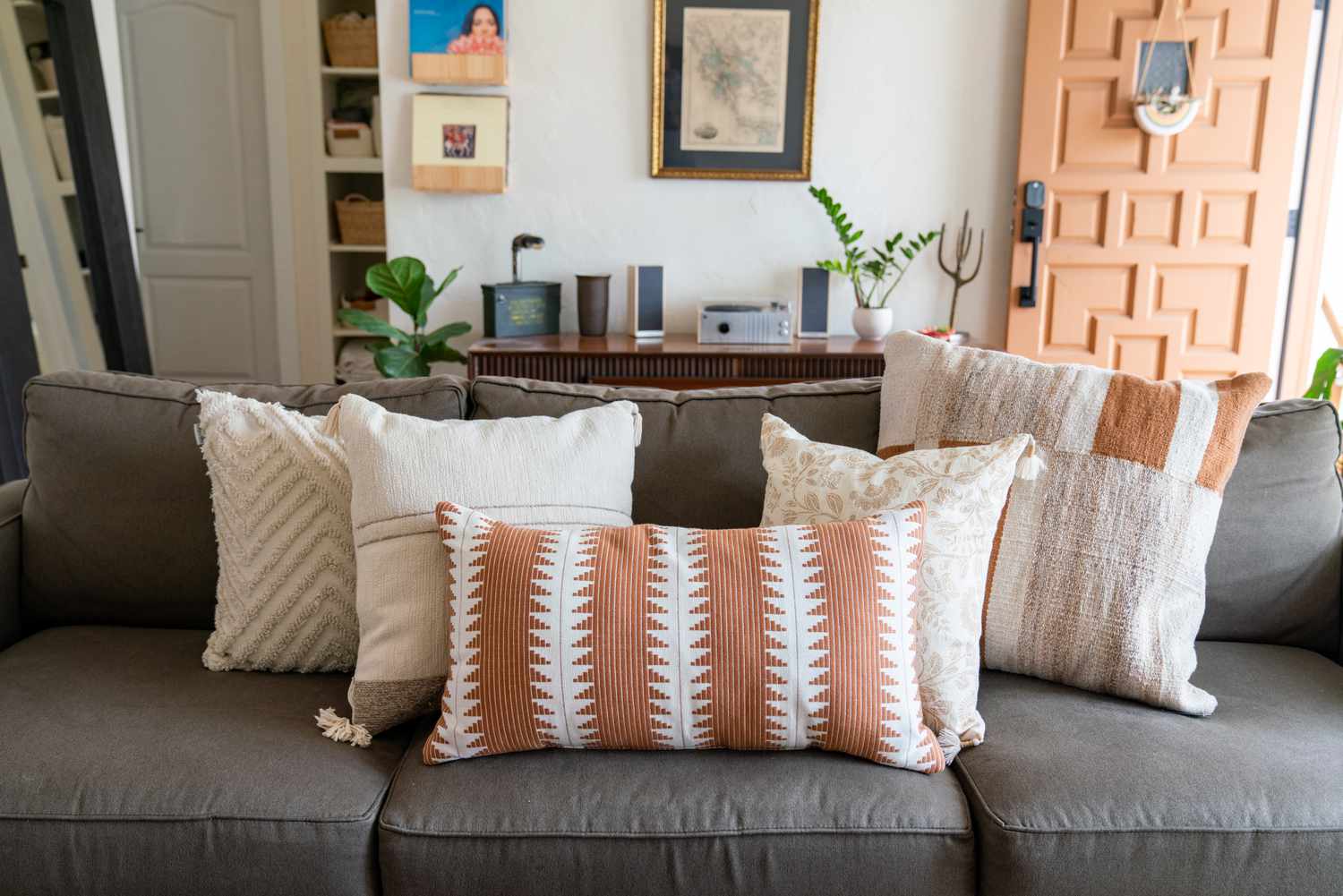 Gray couch covered with patterned throw pillows near front entrance