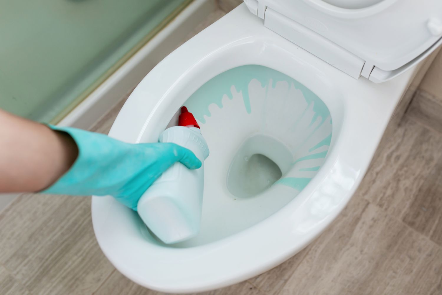 person using toilet bowl cleaner