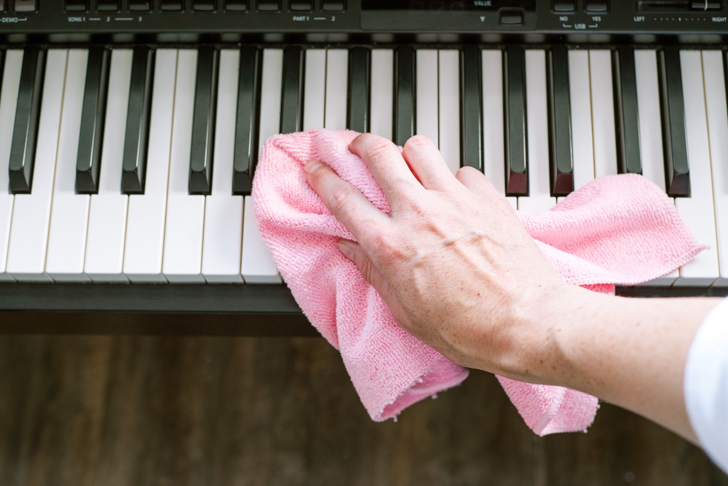 Persona limpiando teclas de piano de plástico