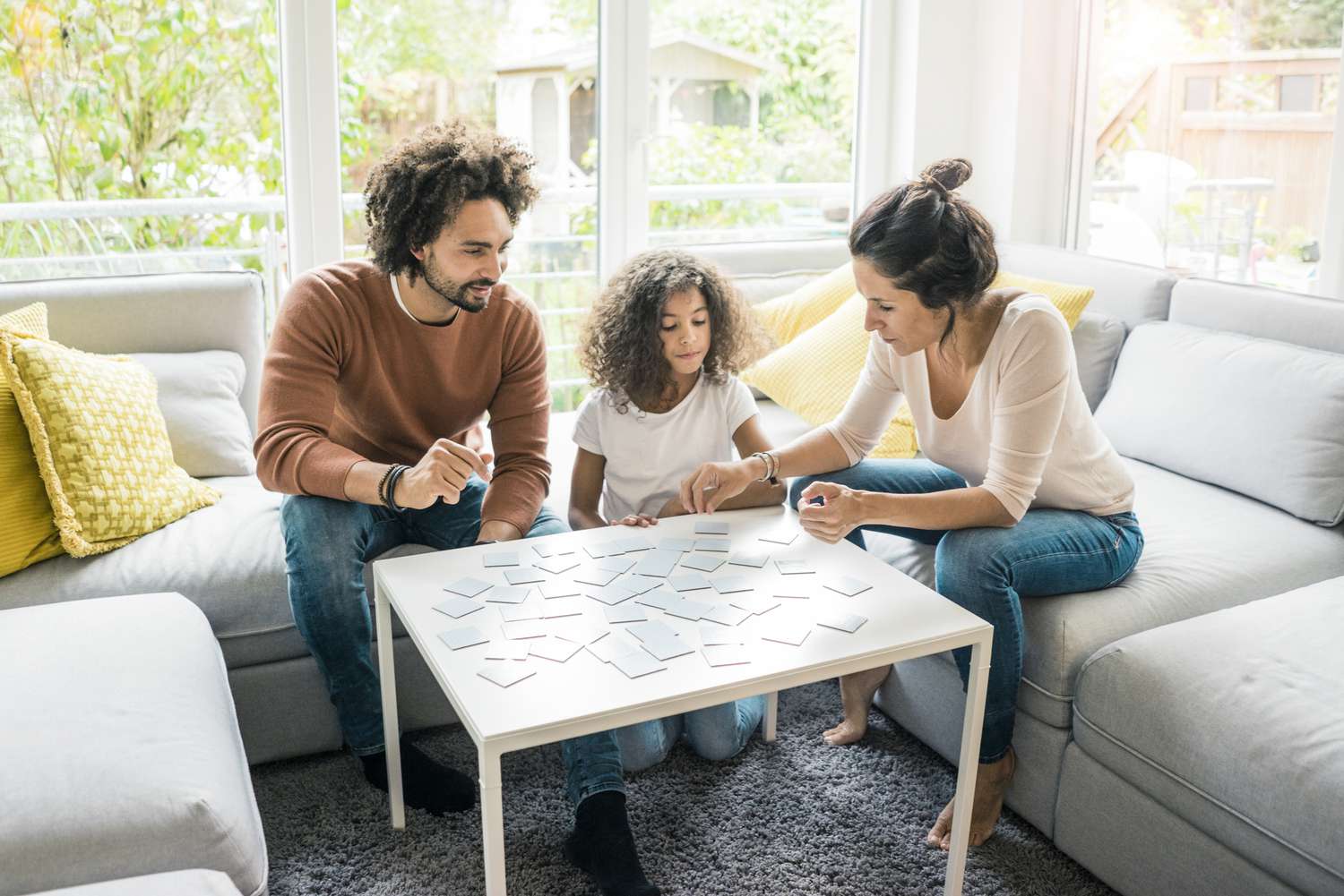 Eine dreiköpfige Familie spielt gemeinsam ein Brettspiel.