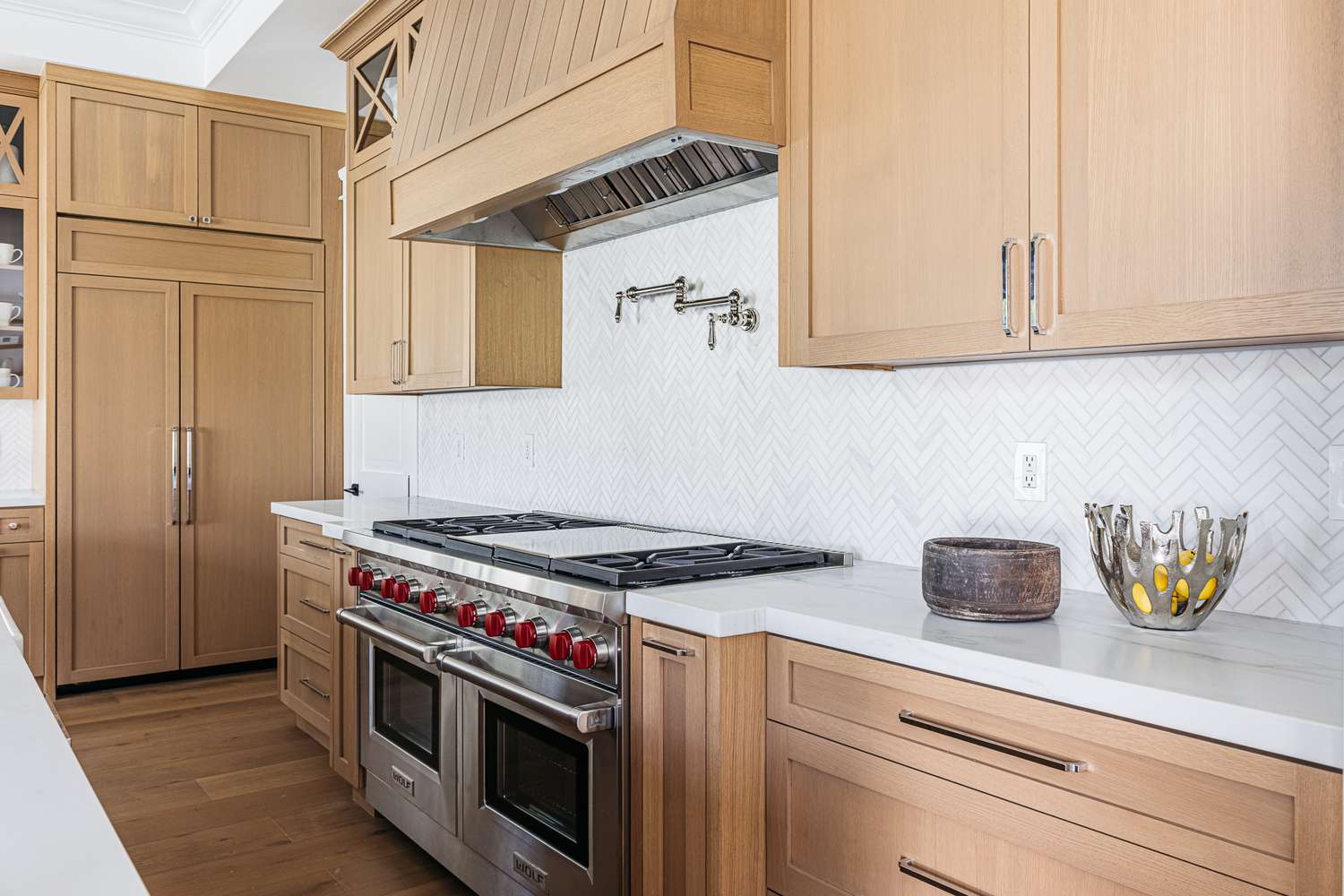 Salpicadero de azulejos en espiga blanca en cocina con armarios de madera