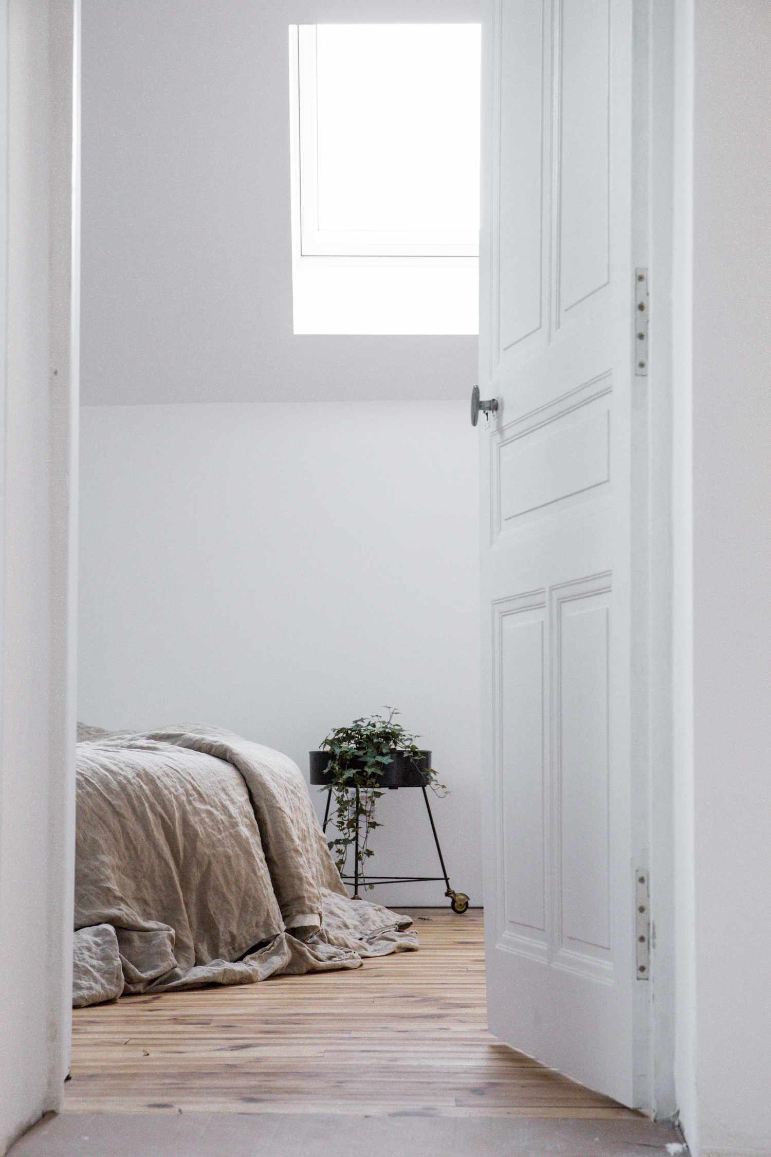 Blick in ein weißes Schlafzimmer durch die Tür