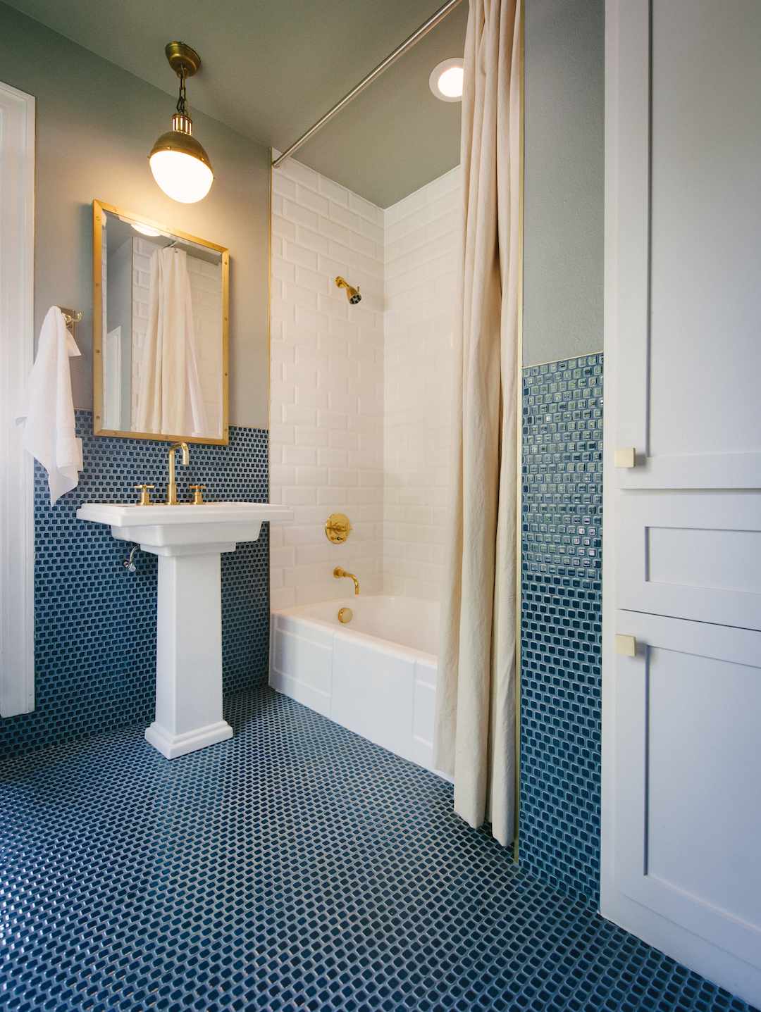 Gold fixtures in blue and green bathroom