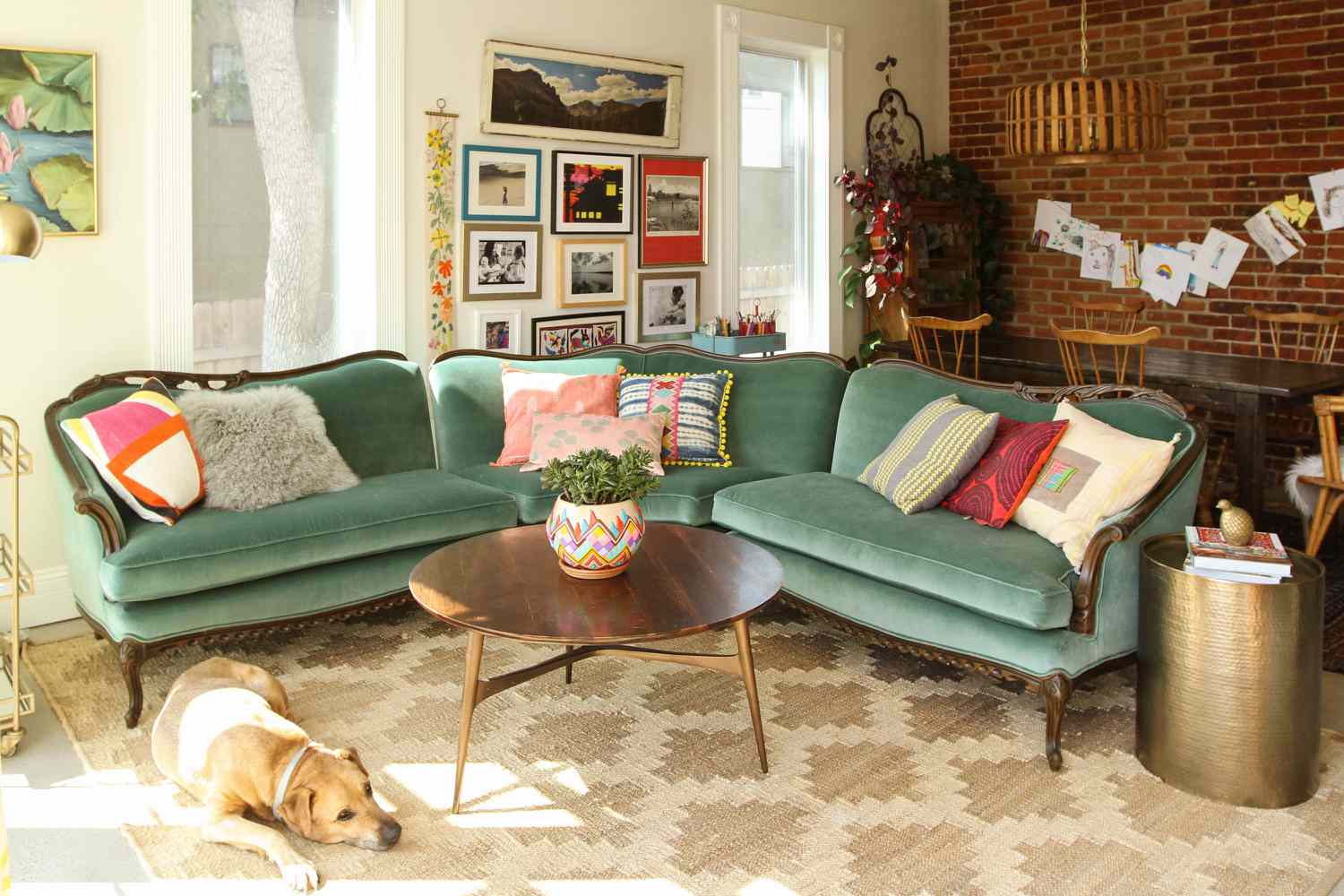 Teal vintage couch covered with patterned throw pillows in living room