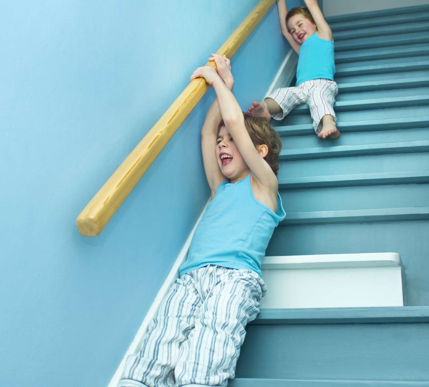 Kinder rutschen von einem Geländer
