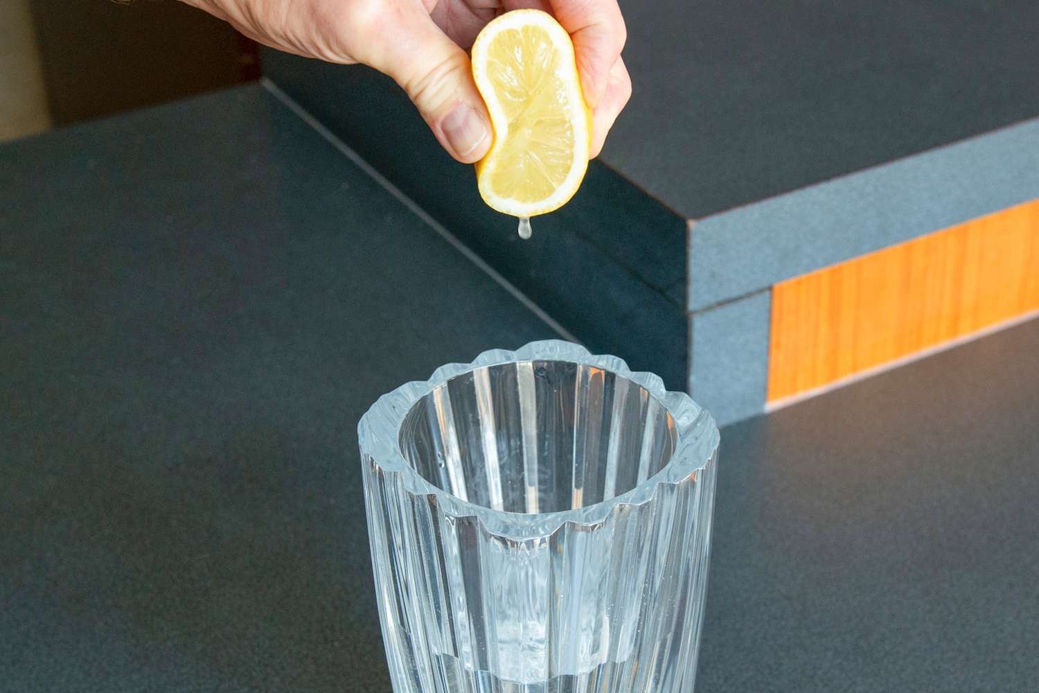 Tranche de citron coupée et pressée sur un vase en verre avec de l'eau