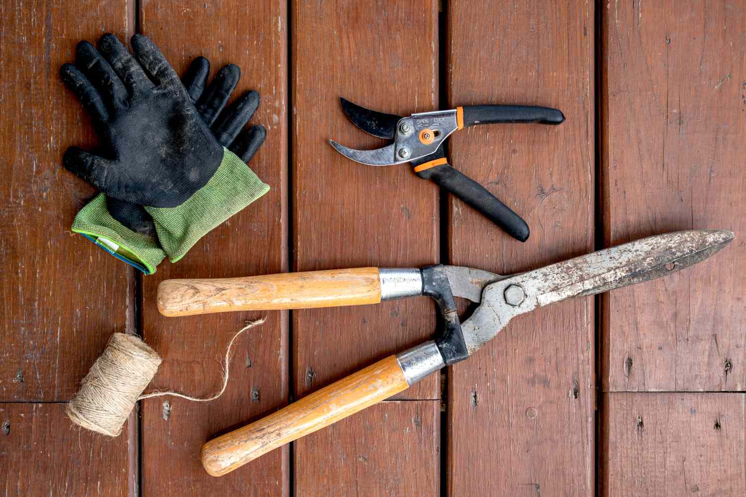 Materiais e ferramentas para treinar e podar rosas trepadeiras em uma superfície de madeira