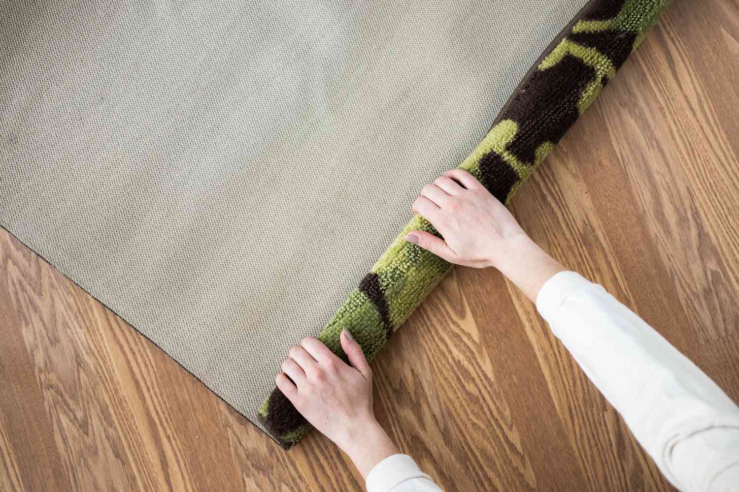 Grüner und brauner Teppich aufgerollt, damit er flacher liegt