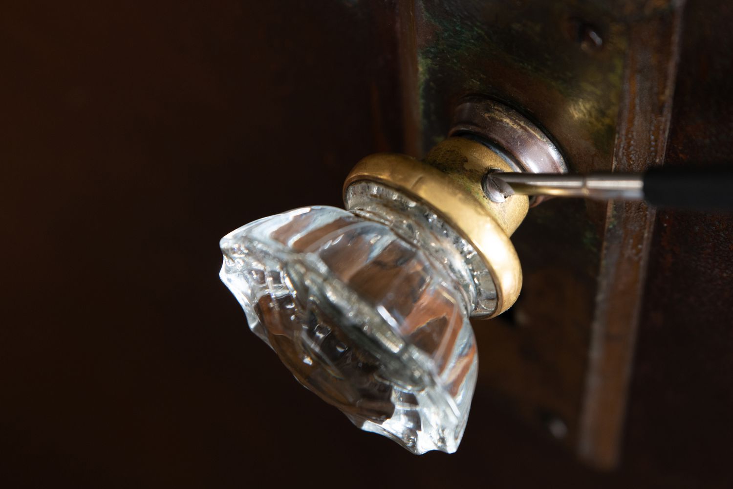 Set screw being tightened on spinning doorknob with screwdriver