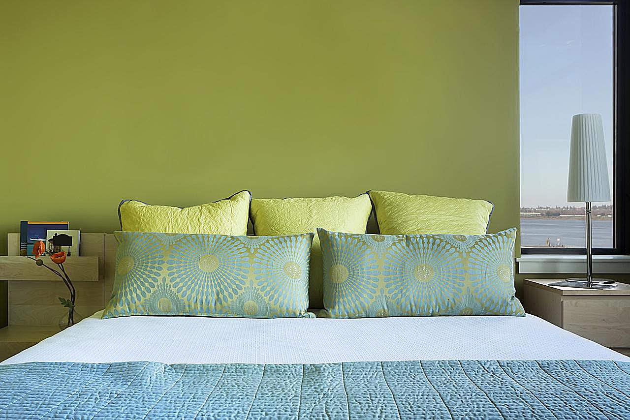 Modernes Schlafzimmer mit kräftigen Farben und Blick auf den Fluss.