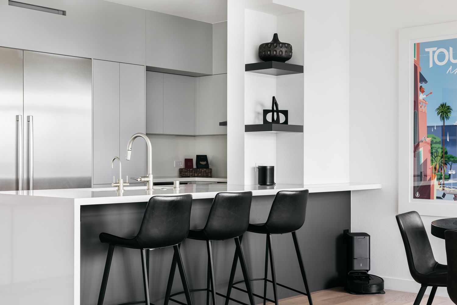 Cozinha moderna com armários cinza-claro, eletrodomésticos de aço inoxidável e móveis pretos