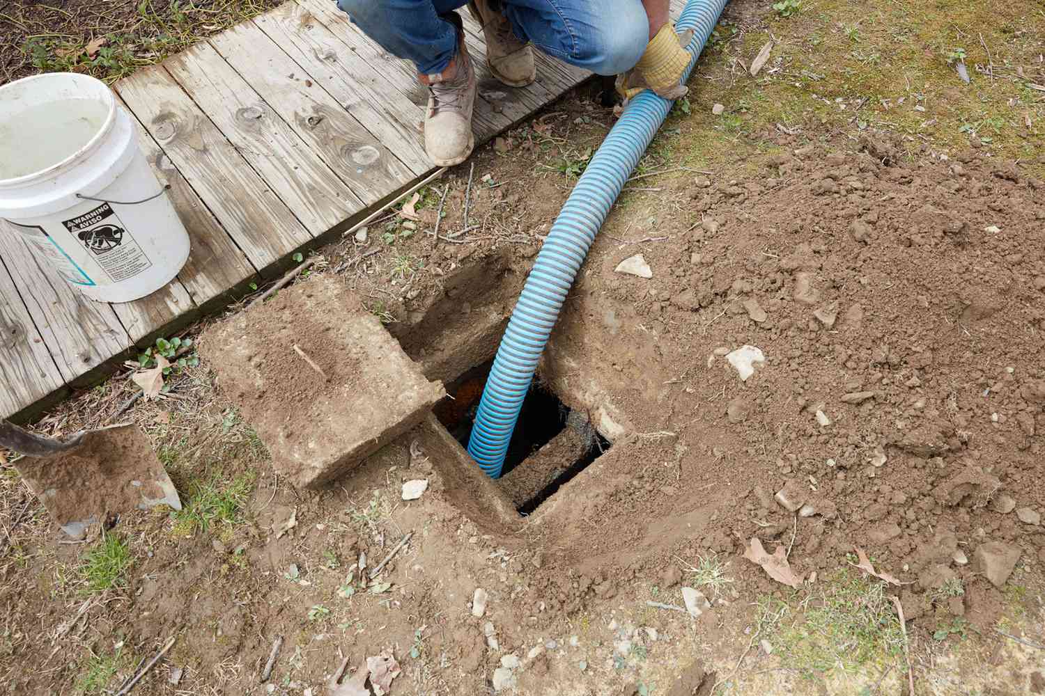 Long tube bleu allant dans la fosse septique sous le sol 