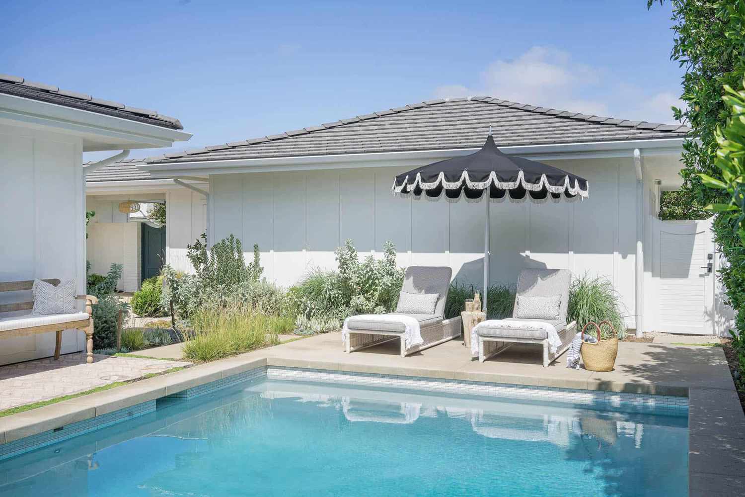 Una piscina en el patio trasero con zona de estar