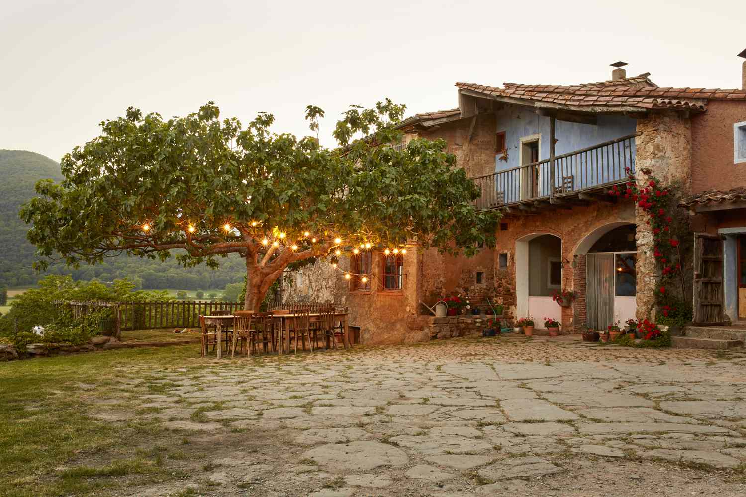 Villa mit Essbereich im Freien und Baum mit Lichterketten