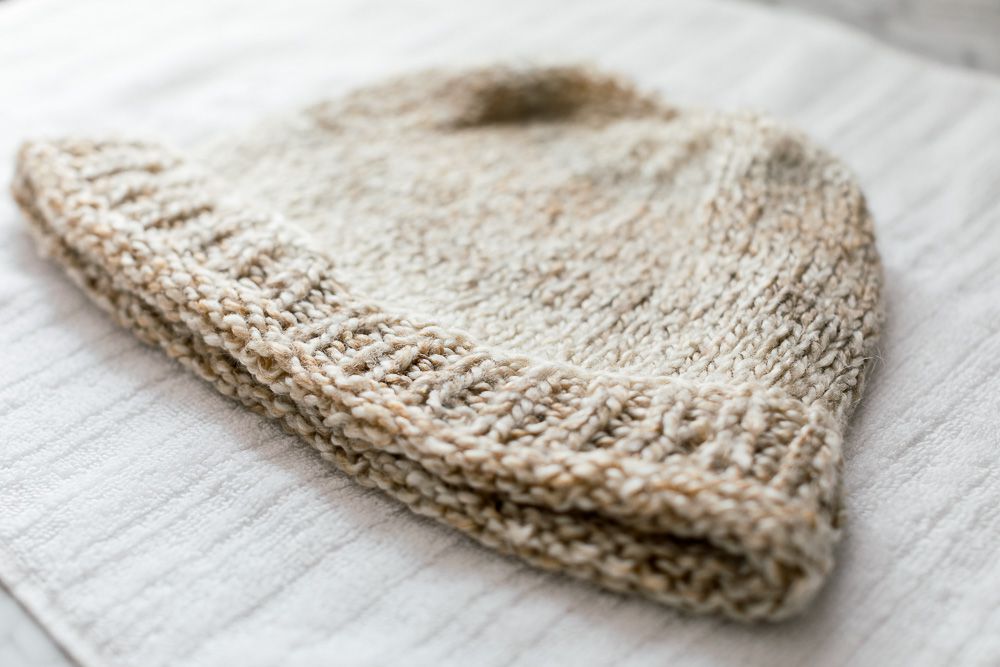 Un bonnet tricoté séchant sur une serviette