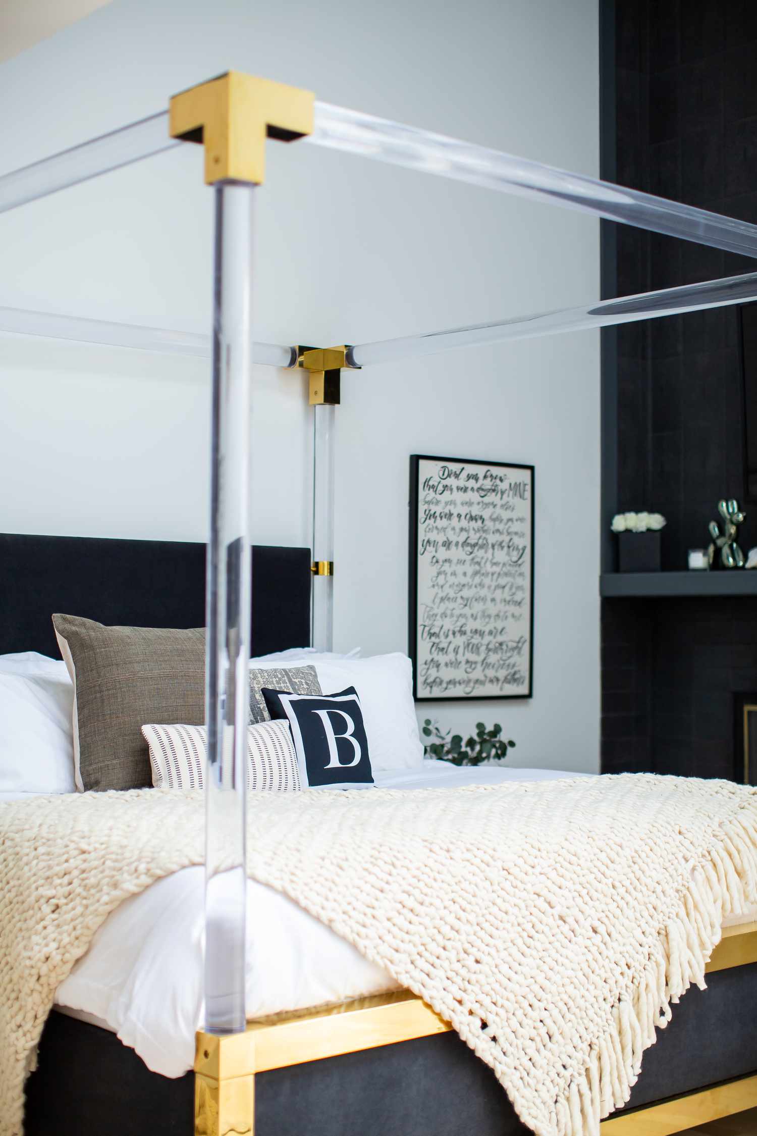 Schlafzimmer mit Säulenhimmelbett und neutraler Bettwäsche.