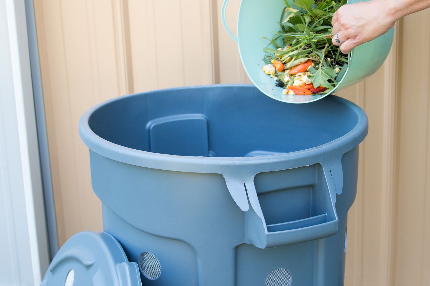 Organische Materialien und Essensreste in den Komposter der Mülltonne gegeben