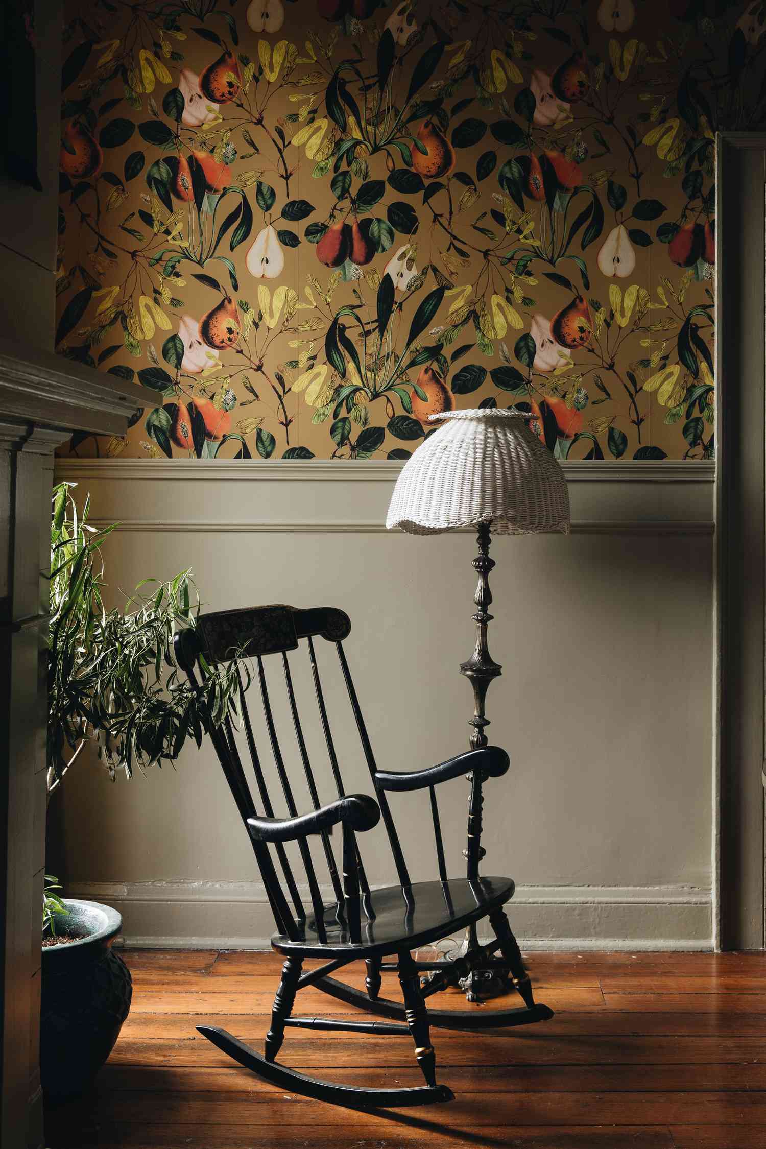 rocking chair in corner with vintage lamp and wallpaper