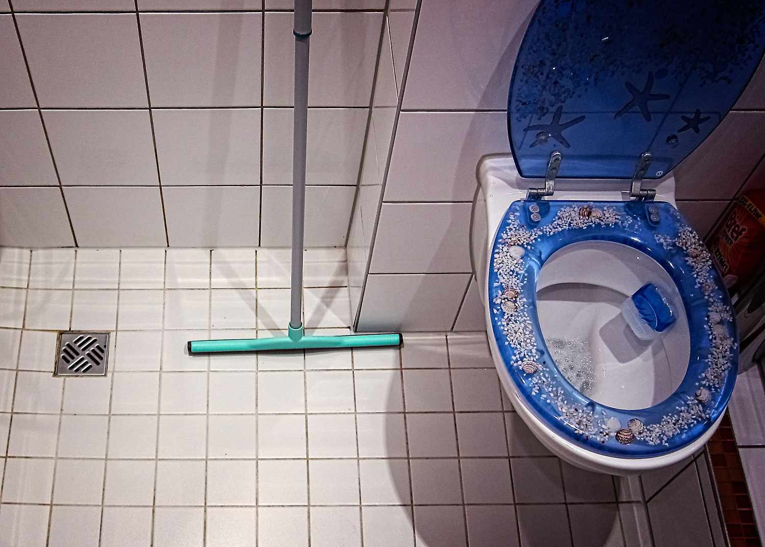 Hochformatige Ansicht eines blauen und glitzernden Toilettensitzes