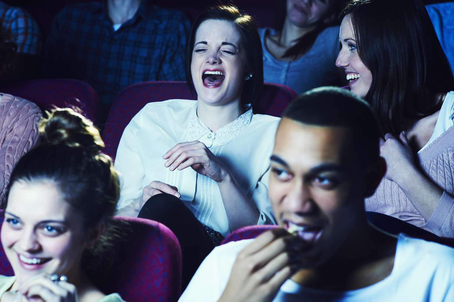 Lachende Frauen in einem Kino.