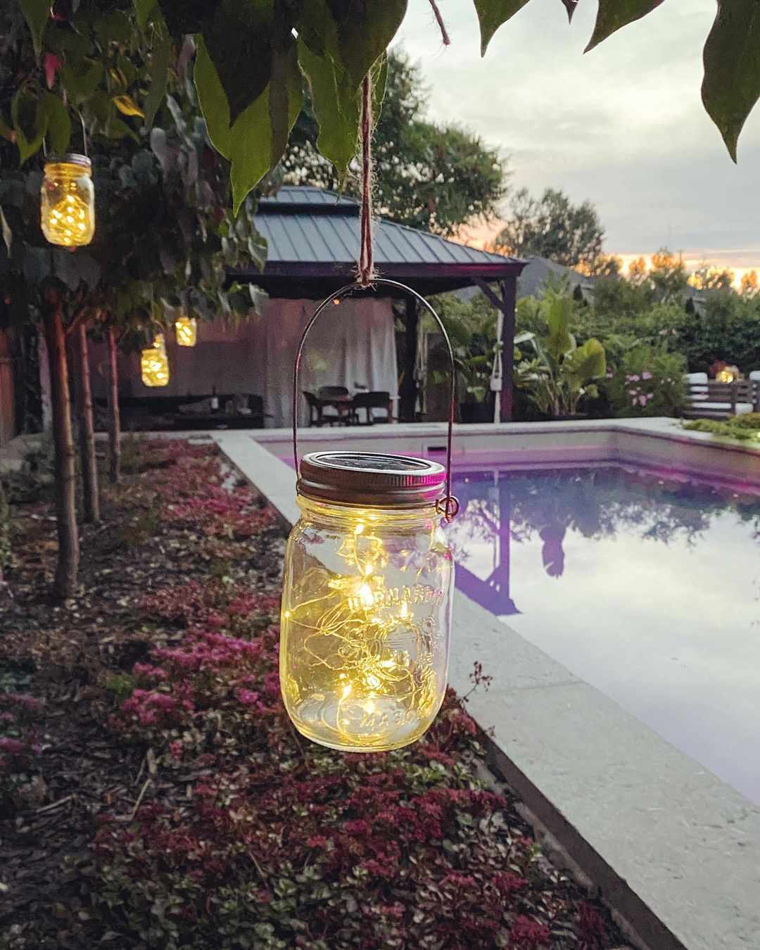 Mason jar string lights hanging around pool