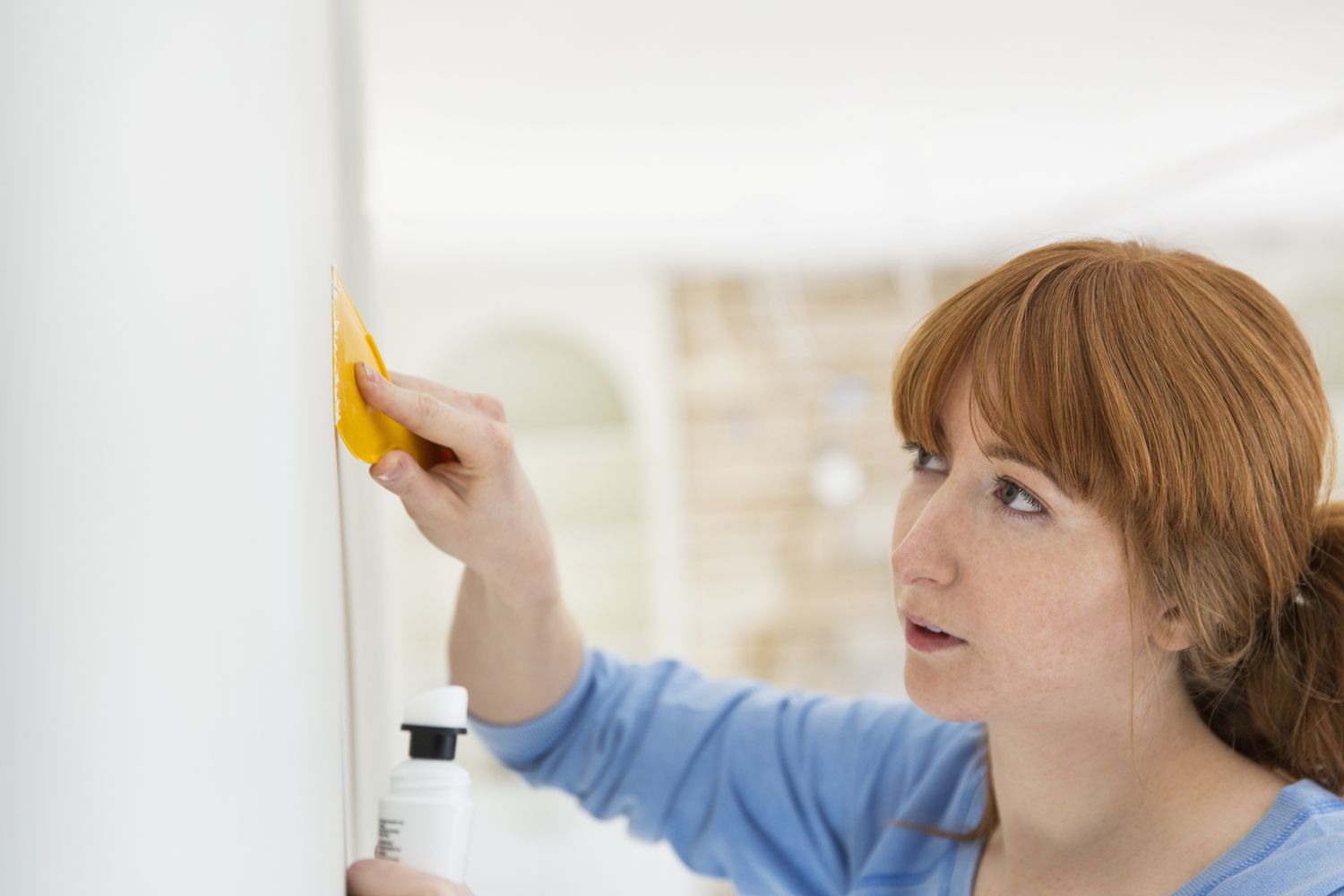 Eine Frau repariert Glas mit einem Spachtel