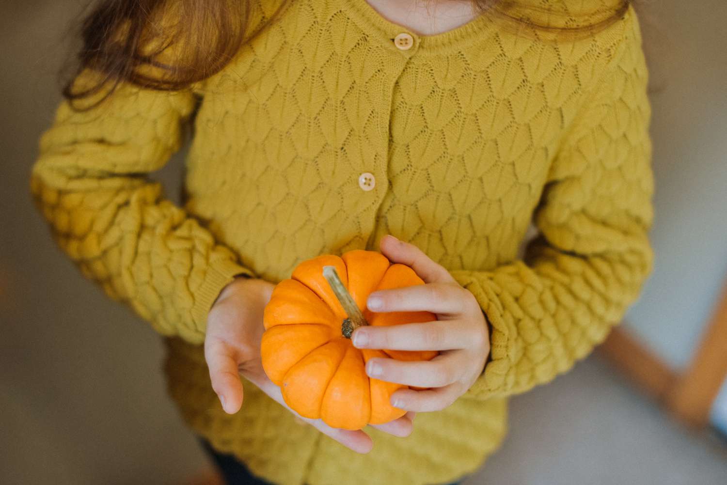 girl holding small pumpkin