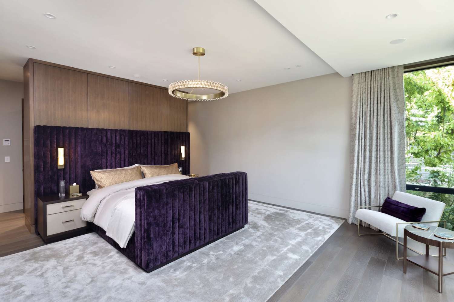 Graues Schlafzimmer mit lila Samtbettgestell 