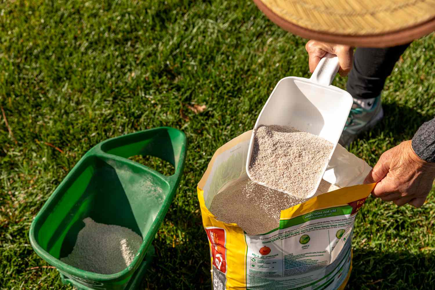 Lawn fertilizer being poured into mower 