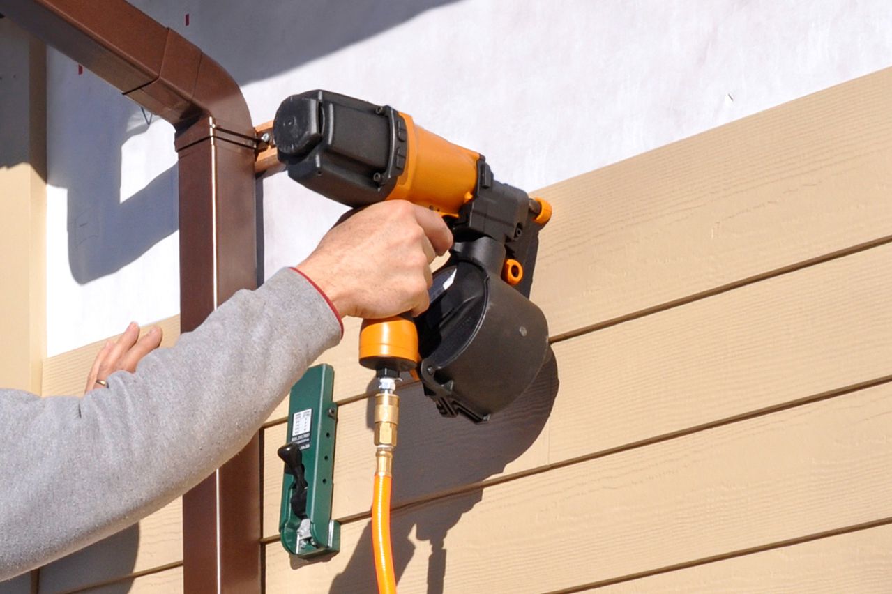 Person using a siding nail gun